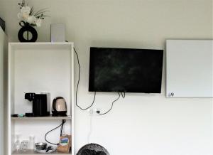 TV de pantalla plana colgada en la pared en Panorama Box op Camping de Stal en Drijber