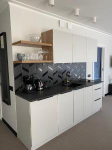 斯維諾烏伊希切的住宿－Apartamenty MGA ApartPark，厨房配有白色橱柜和黑色台面