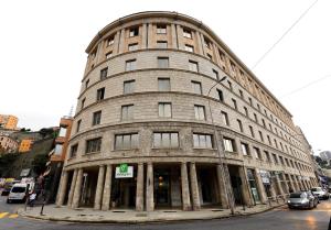 a large building on the corner of a street at Holiday Inn Genoa City, an IHG Hotel in Genoa