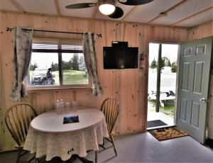 a room with a table with chairs and a television at WildExodus Outdoors in Timmins