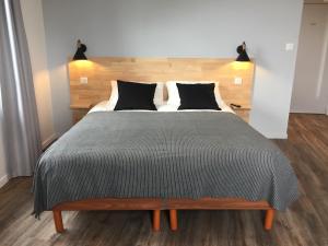 a bedroom with a large bed with black pillows at une nuit sur le pont 1 in Landerneau
