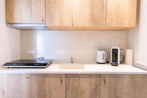 a kitchen with a sink and a laptop on a counter at Luxstay Karben Neue Mitte - Self-Check-In in Karben