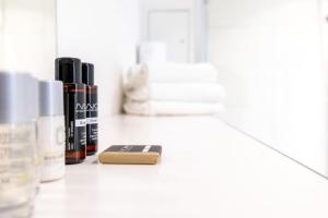 a bathroom counter with bottles of essential oils and a soap at Luxstay Karben Neue Mitte - Self-Check-In in Karben