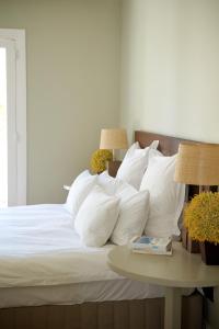 a bed with white pillows and a table with lamps at South Hill in Elgin