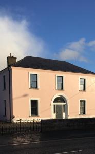 een groot wit huis met een zwart dak bij Tom Blake House in Kells