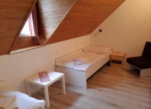 um pequeno quarto com uma cama e uma janela em Penzion u Hradilů em Vrbno pod Pradedem