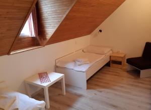 Habitación pequeña con cama y ventana en Penzion u Hradilů, en Vrbno pod Pradědem