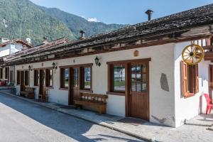 un edificio con panchine e un orologio sul lato di esso di Appartamento Adamello 12 a Pinzolo