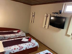 a room with two beds and a flat screen tv at Motel Dilijans in Vidin