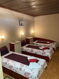 a group of three beds in a room at Motel Dilijans in Vidin