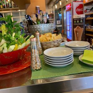 un mostrador con platos y tazones de comida sobre una mesa en Hotel Piada D'Oro en Riccione