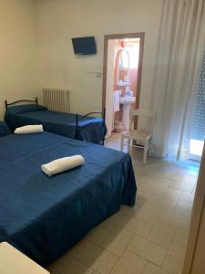a bedroom with two beds with towels on them at Hotel Piada D'Oro in Riccione