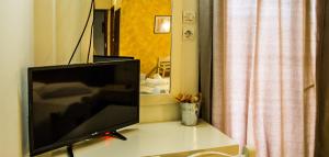 telewizor z płaskim ekranem siedzący na stole w obiekcie Hotel Alos w mieście Almiros