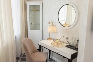 a white desk with a chair and a mirror at Altay Hotel in Barnaul
