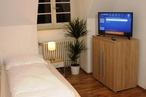 um quarto com uma cama e uma televisão num armário em Restaurant Engel am Marktplatz Tuttlingen em Tuttlingen