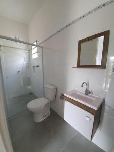 uma casa de banho branca com um WC e um lavatório em Suítes Laure em Lindoia
