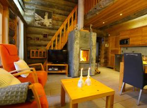 a living room with a fireplace in a log cabin at Villa Vuossel in Ruka