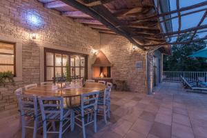 an outdoor patio with a wooden table and chairs at Family Villa Lipica with private pool and jacuzzi in Pazin