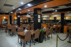 a restaurant with tables and chairs and a bar at Hotel San Martin in Hermosillo