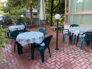 a group of tables and chairs with flowers on a patio at Hotel Franca in Riolo Terme