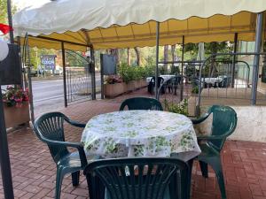 un tavolo con sedie, un tavolo e una tenda di Hotel Franca a Riolo Terme