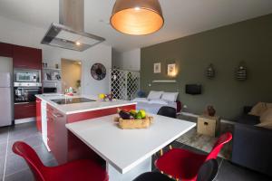 cocina y sala de estar con mesa y sillas rojas en Quinta das Giestas, en Ribeira Grande