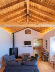a living room with wooden ceilings and blue couches at Casa do Castanheiro - Nordeste, Açores in Nordeste