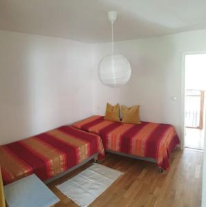 1 dormitorio con 2 camas y luz colgante en Moderne Wohnung mit Studio in Bauernhausscheune am See en Biersdorf