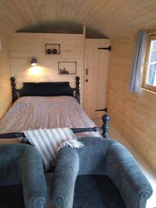 een slaapkamer met een bed in een houten hut bij Langs De Maas in Boxmeer