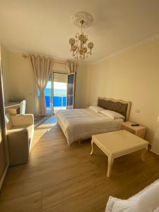 a bedroom with a bed and a couch and a table at Hotel 3 Vellezerit in Durrës