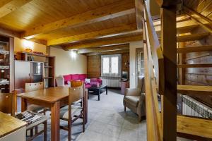 a kitchen and living room with a wooden ceiling at MAIANS - Peu del Riu 122 - Vall d'Incles - Soldeu in Incles