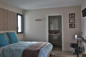 a bedroom with a bed and a bathroom with a sink at Maison Cube in Saint-Didier-au-Mont-dʼOr