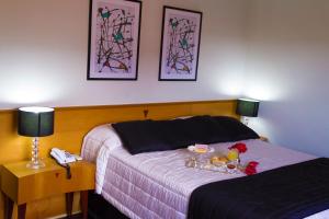 een slaapkamer met 2 bedden en een dienblad met eten erop. bij Hotel Canada in Ribeirão Preto