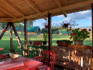 a patio with a table and chairs under a wooden roof at Bungalovi Mijakovici in Pljevlja
