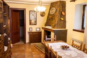 une salle à manger avec une table et une cheminée dans l'établissement El Portal de la Sierra de Francia II, à San Miguel de Valero