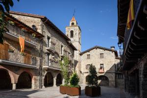 ein altes Gebäude mit einem Turm und einer Kirche in der Unterkunft La Calma de Bellver in Bellver de Cerdanya