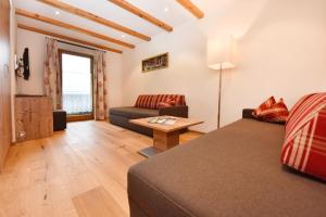 a living room with a bed and a couch at Gasthaus & Pension Alphorn in Lech am Arlberg
