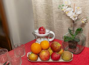um prato de frutas com maçãs e laranjas numa mesa em B&B Dei Cavalieri em Pisa