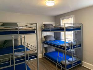 Habitación con 3 literas y sábanas azules. en ☆☆ Modern Coed Dorm in Reading ☆☆ en Reading