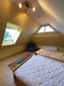 a bedroom with two windows and a bed in a attic at Ferienwohnung am Deichweg in Cappel-Neufeld