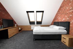 um quarto com uma cama e uma parede de tijolos em Ostoja Garden em Brody