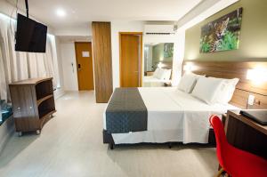ein Hotelzimmer mit einem Bett und einem TV in der Unterkunft Bristol Umarizal Belem in Belém