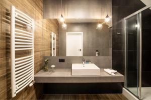 ein Bad mit einem Waschbecken und einem Spiegel in der Unterkunft Ostoja Garden in Brody