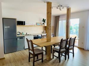 uma cozinha e sala de jantar com uma mesa de madeira e cadeiras em Egria Apartments em Eger