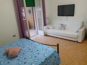 a room with a bed and a couch and a television at A casa di Adele in Caserta