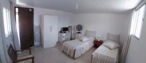 een witte kamer met 2 stoelen en een televisie bij Acupe de Brotas in Salvador