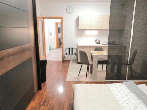 ein Schlafzimmer und eine Küche mit einem Tisch und Stühlen in der Unterkunft Apartman Praha in Prag