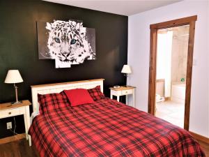 - une chambre avec un lit et une photo d'un tigre dans l'établissement La plus belle vue du secteur - La Forteresse, à Petite-Rivière-Saint-François