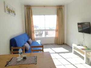 a living room with a table and a blue couch at apartamentos la villa 2 in San Sebastián de la Gomera