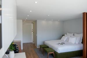 una camera d'albergo con un letto bianco e due sedie di Portovella Lodges & Bungalows a Pala